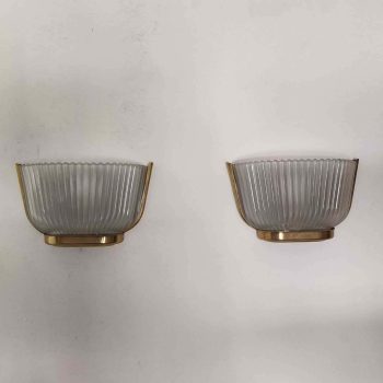 Pair of Archimede Seguso wall lamps with natural light, on a light wall.