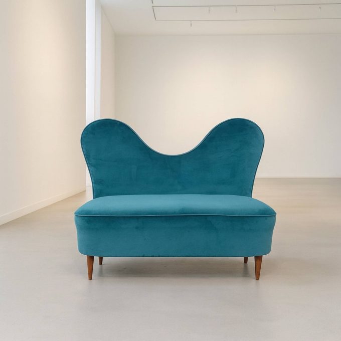 Sofa by Cesare Lacca in turquoise velvet, displayed in a gallery setting.