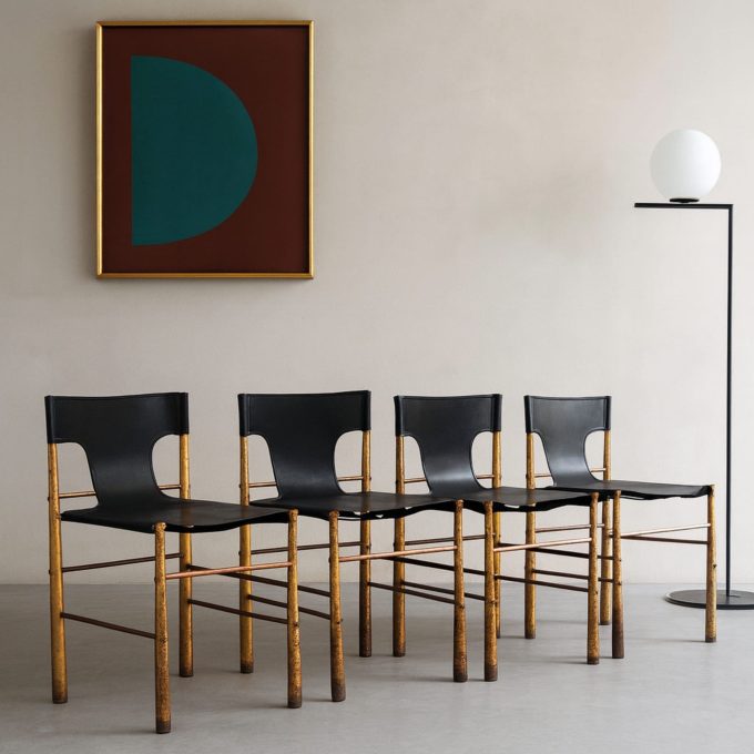 Set di quattro sedie italiane in ottone e pelle nera, anni ’70, nello stile di Frigerio, ambientate in interni moderni.