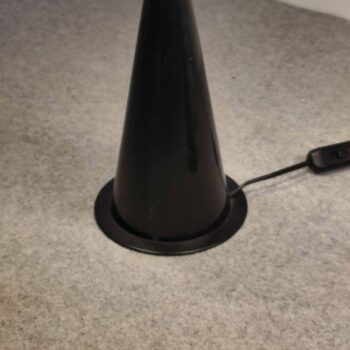 Particolare della base conica in metallo nero di una lampada da tavolo Vistosi degli anni '80.