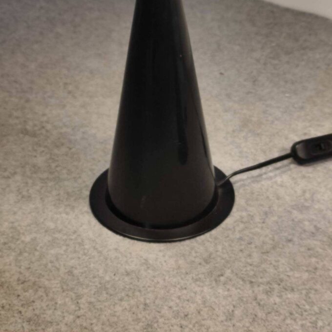 Particolare della base conica in metallo nero di una lampada da tavolo Vistosi degli anni '80.